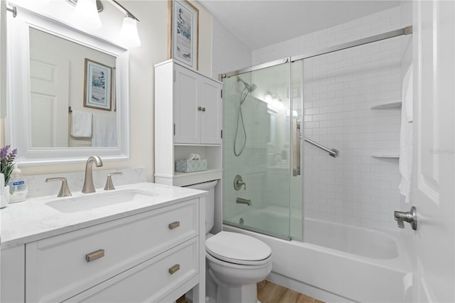 full bathroom with vanity, toilet, wood-type flooring, and combined bath / shower with glass door