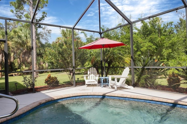 view of pool with glass enclosure and a patio area