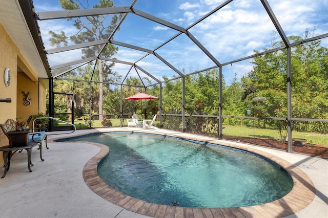 view of pool with glass enclosure and a patio area