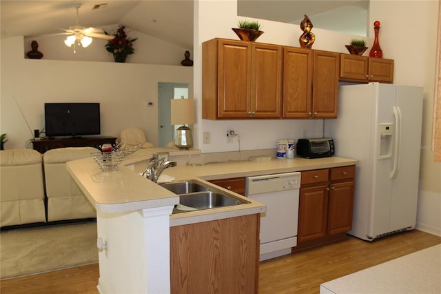 kitchen featuring lofted ceiling, white appliances, sink, light hardwood / wood-style floors, and kitchen peninsula