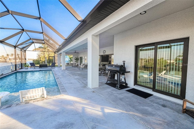 view of swimming pool with a lanai, ceiling fan, a patio area, and grilling area