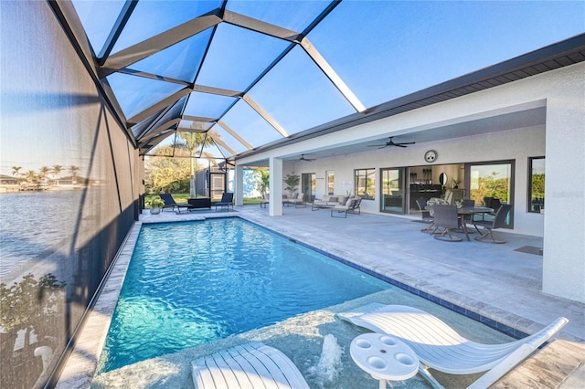 view of pool with a lanai, an outdoor hangout area, ceiling fan, and a patio area