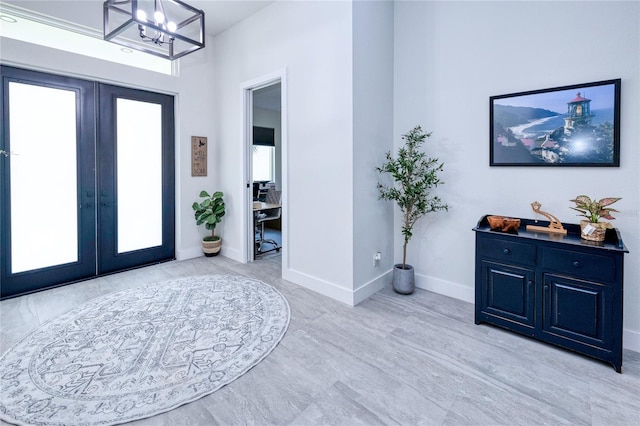 foyer featuring french doors and an inviting chandelier