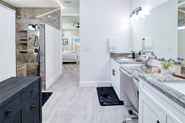 bathroom featuring a tile shower, vanity, and ceiling fan