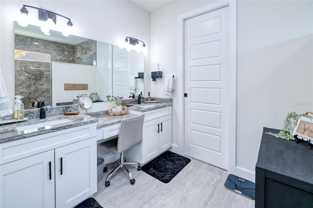 bathroom featuring a tile shower, vanity, and wood-type flooring