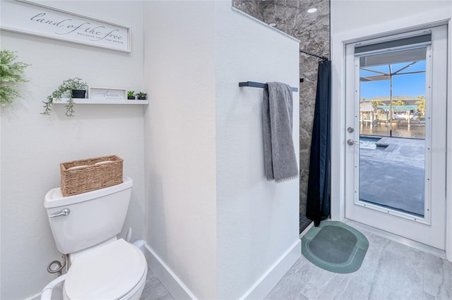 bathroom featuring a shower with curtain and toilet