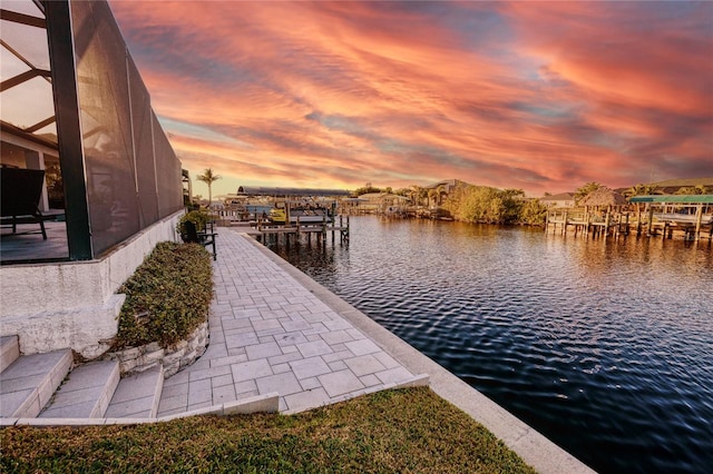 dock area with a lanai and a water view