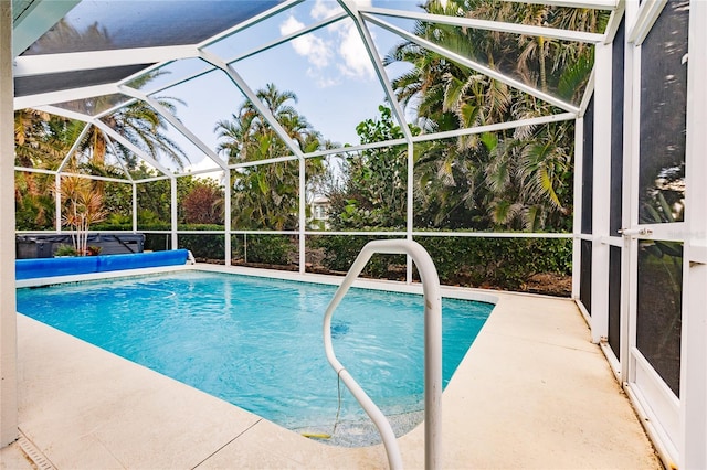 view of pool with glass enclosure and a patio area