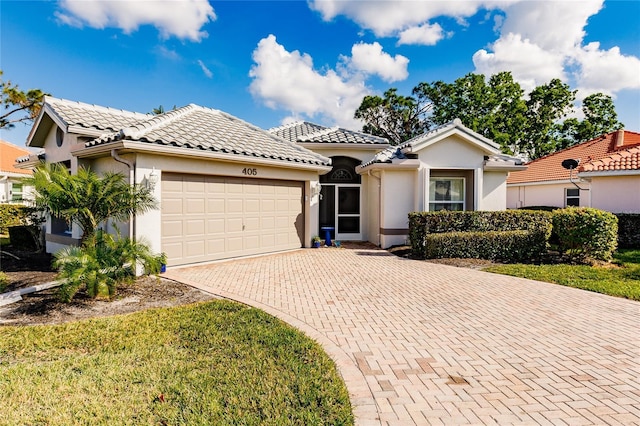 mediterranean / spanish home with a front yard and a garage