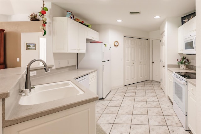 kitchen with light tile patterned flooring, white appliances, white cabinetry, and sink