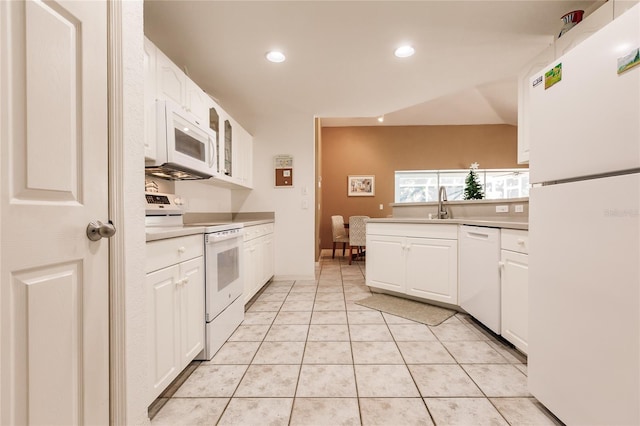 kitchen featuring white cabinets, light tile patterned floors, and white appliances