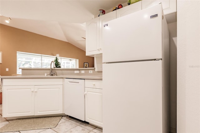 kitchen with sink, white cabinets, lofted ceiling, white appliances, and light tile patterned floors