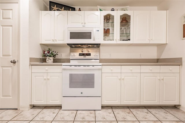 kitchen with light tile patterned floors, white appliances, and white cabinetry