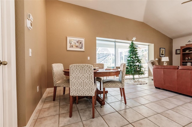 dining room featuring light tile patterned floors and vaulted ceiling