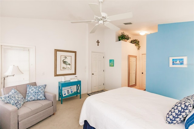 carpeted bedroom with ceiling fan and high vaulted ceiling