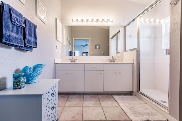 bathroom featuring a shower with door, vanity, and tile patterned flooring