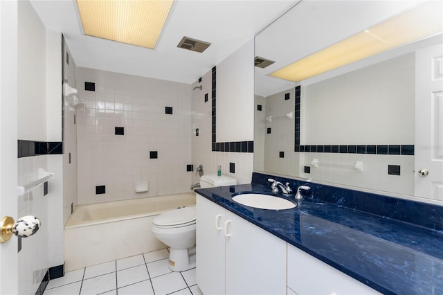 full bathroom with tile patterned floors, vanity, tiled shower / bath combo, and tile walls