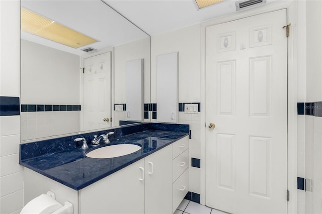 bathroom with tile patterned floors, tile walls, and vanity