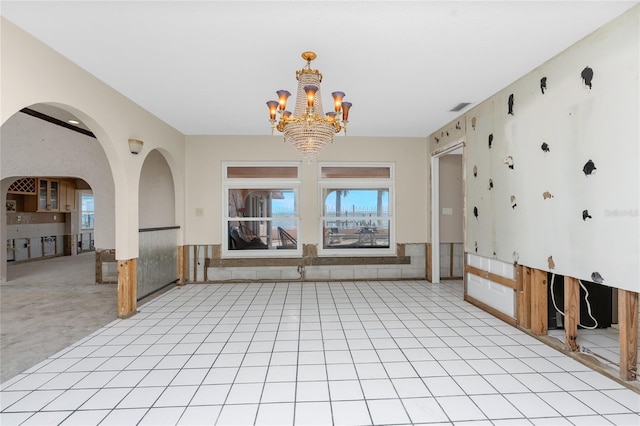 unfurnished living room featuring light colored carpet and a chandelier