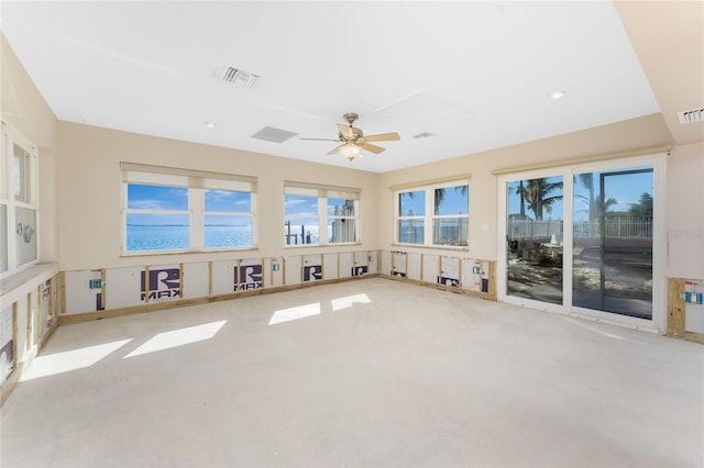 interior space with ceiling fan, a water view, and concrete flooring