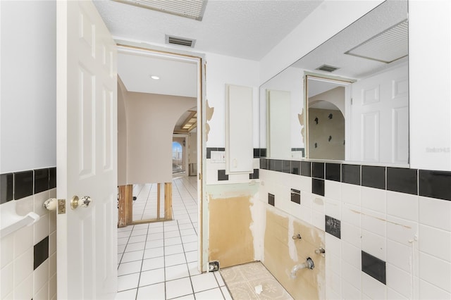 bathroom with a textured ceiling and tile patterned floors