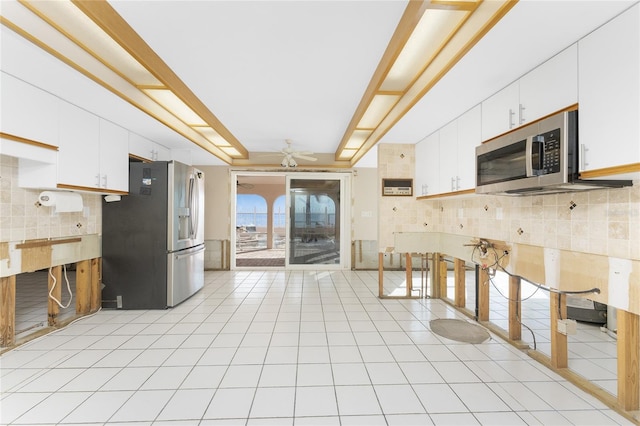 kitchen featuring ceiling fan, white cabinets, stainless steel appliances, and light tile patterned floors