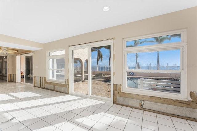 interior space with light tile patterned floors and ceiling fan