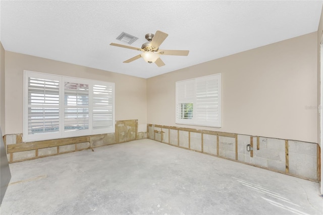 unfurnished room with ceiling fan, concrete floors, and a textured ceiling