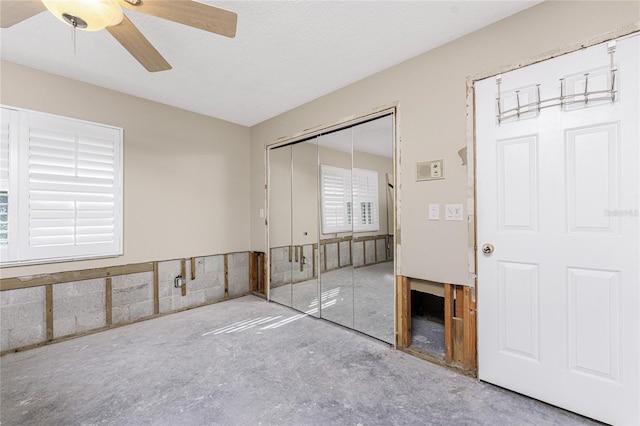 unfurnished room featuring concrete flooring, ceiling fan, and a textured ceiling