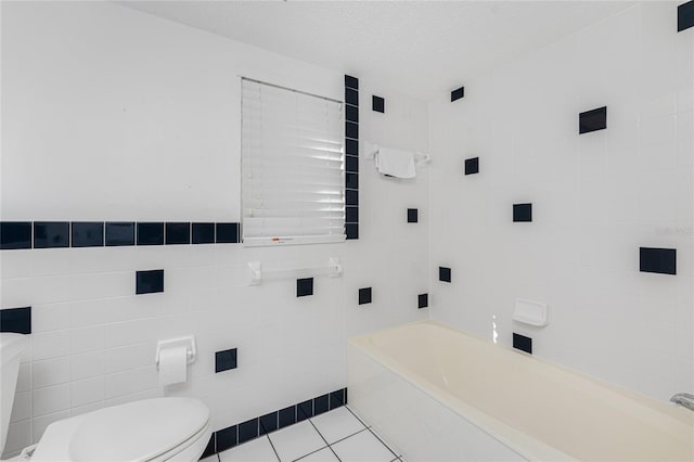 bathroom featuring a textured ceiling, tile walls, tile patterned flooring, toilet, and a bathing tub