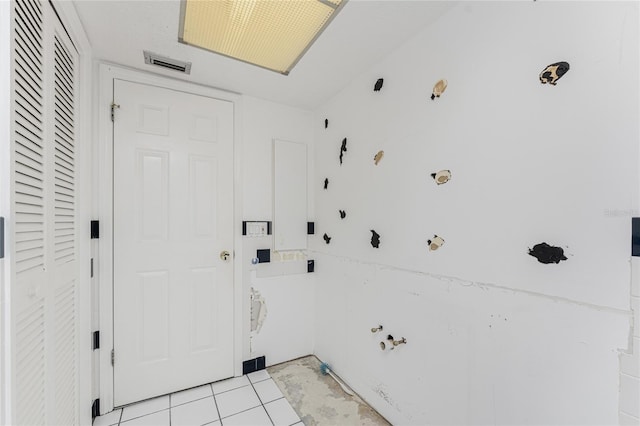 clothes washing area featuring light tile patterned floors