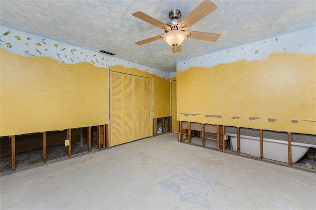 interior space featuring ceiling fan and a textured ceiling