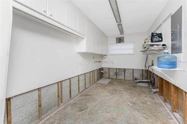 interior space with white cabinetry and electric panel