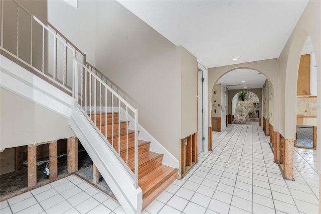 stairs with a fireplace and tile patterned floors