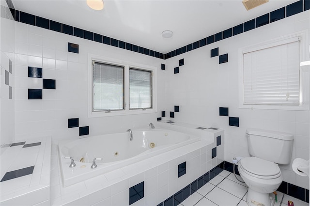 bathroom with tile patterned floors, tile walls, toilet, and a relaxing tiled tub