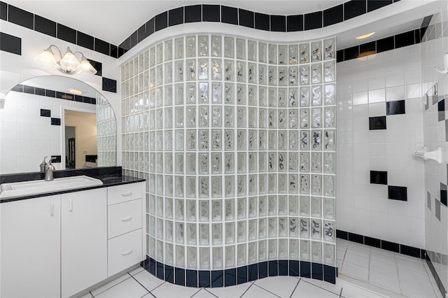 bathroom featuring tile walls, tile patterned flooring, vanity, and walk in shower