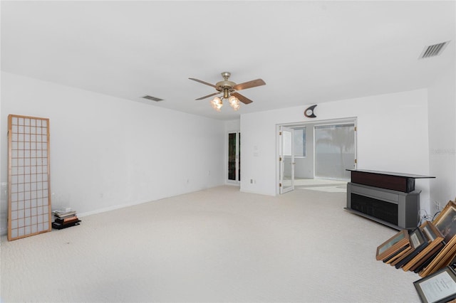 unfurnished living room featuring ceiling fan and carpet floors