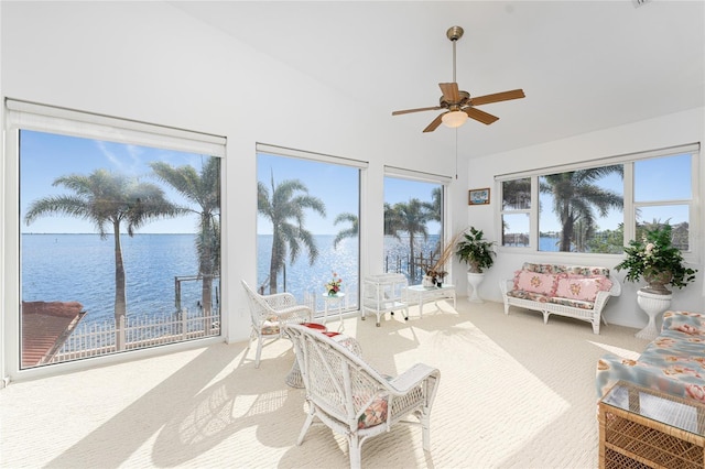 sunroom featuring ceiling fan and a water view