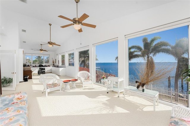 sunroom / solarium with a water view, ceiling fan, and lofted ceiling