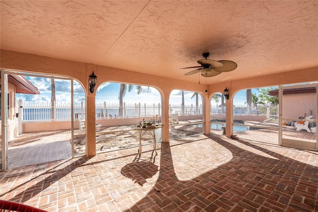 view of patio featuring ceiling fan and a fenced in pool