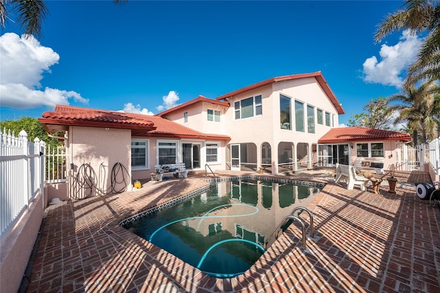 back of house with a fenced in pool and a patio