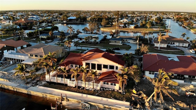 aerial view at dusk featuring a water view