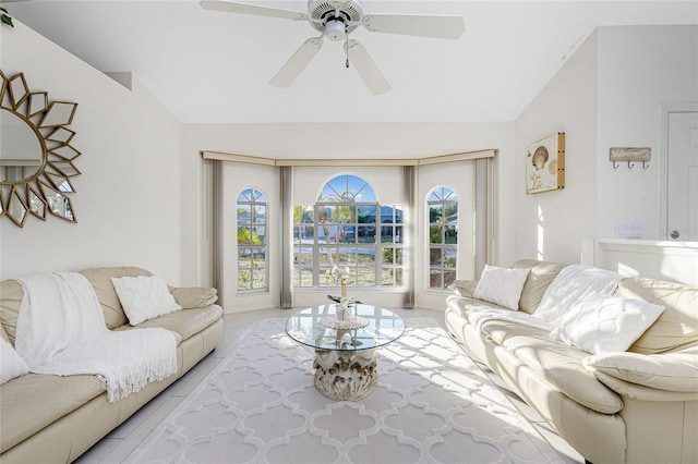 living room featuring ceiling fan, lofted ceiling, and light tile patterned floors