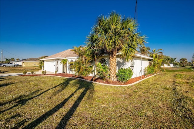 view of front of property with a front yard and a garage