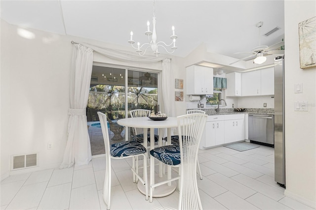 kitchen featuring ceiling fan with notable chandelier, sink, stainless steel dishwasher, light tile patterned floors, and white cabinetry