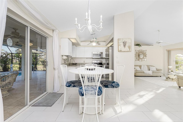 tiled dining space with ceiling fan with notable chandelier, lofted ceiling, and sink