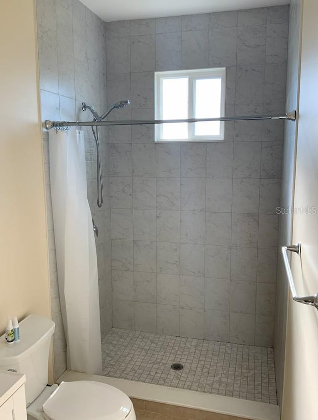 bathroom featuring tile patterned floors, vanity, toilet, and curtained shower