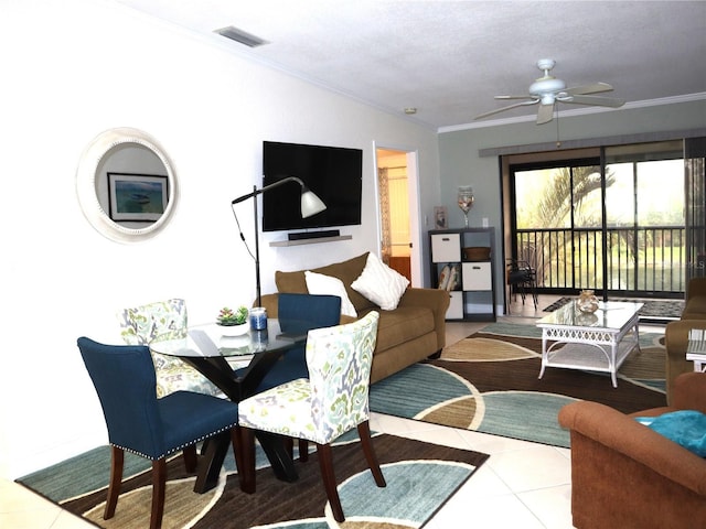 tiled living room featuring ceiling fan, ornamental molding, and a textured ceiling