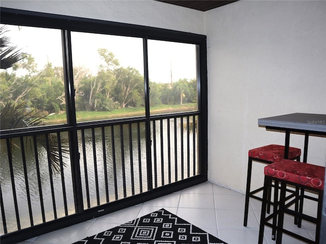 sunroom featuring a water view