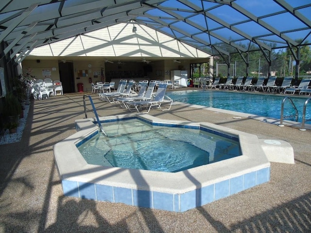 view of pool featuring glass enclosure and a patio